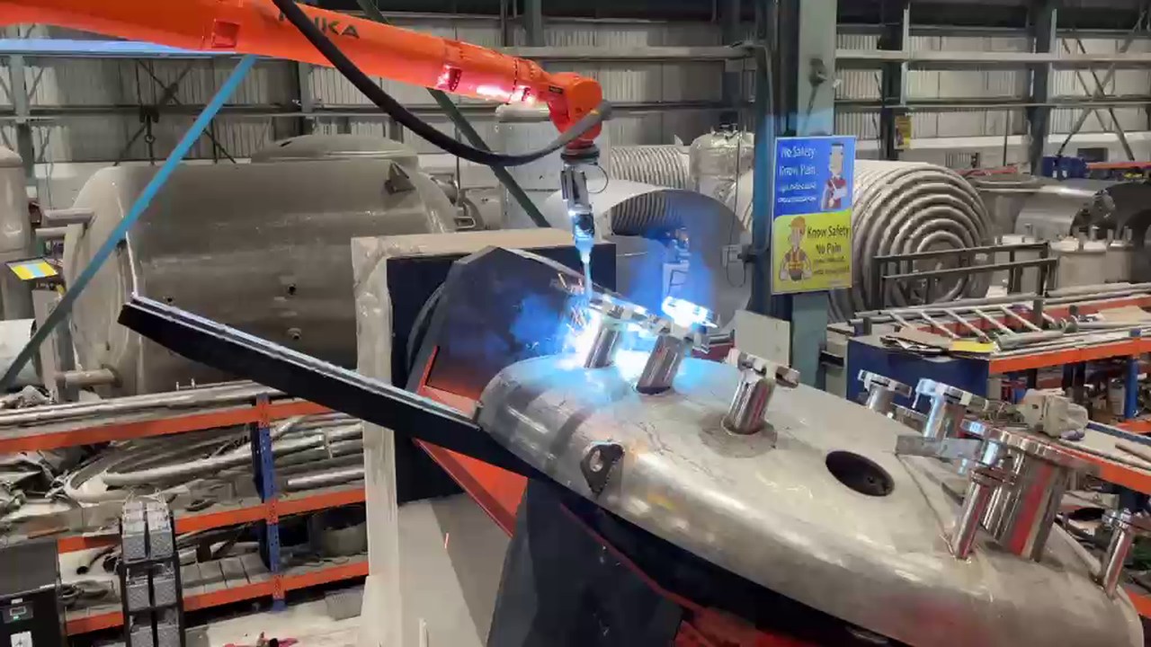 Turnkey robotic pressure vessel welding cell with KUKA robot welding dished end nozzle on heavy positioner